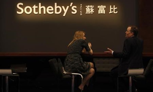 Staff members chat during Sotheby's preview in Hong Kong April 2, 2013 - REUTERS/Bobby Yip