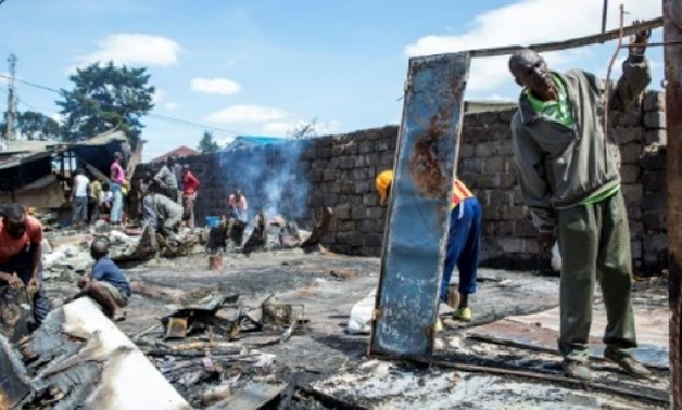 Residents of Nairobi's Kibera slum clean up a shop that was burned down during clashes after President Uhuru Kenyatta was declared the winner of last week's protest-hit election - AFP / by Hazel WARD 