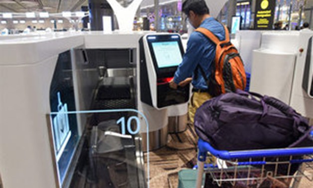 A passenger checks-in his luggage using an automated booth at the newly- opened - AFP