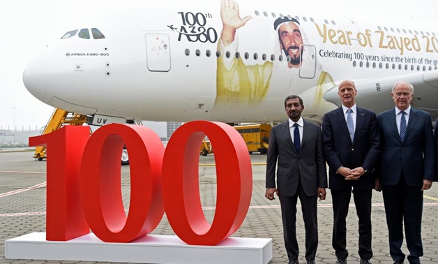 Tom Enders, CEO of Airbus (C), Sheikh Ahmed bin Saeed Al Maktoum, Emirates' chairman and CEO (L) and Tim Clark President Emirates Airlines, pose for media during a delivery ceremony of Emirates' 100th Airbus A380 at the German headquarters of aircraft com