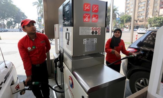 A female employee works alongside a male colleague at a petrol station in Cairo, Egypt, February 24, 2016 - REUTERS
