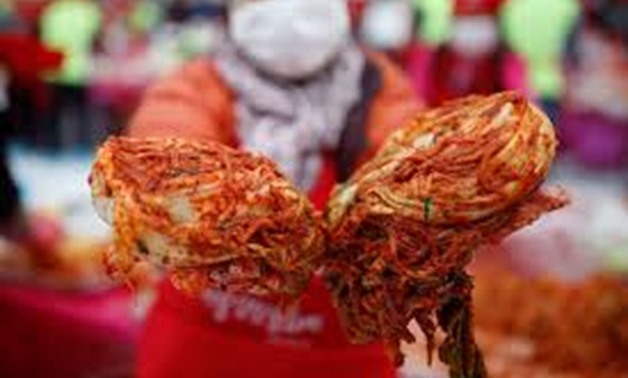 A woman poses for photographs with traditional side dish 'Kimchi' during the Seoul Kimchi Festival in central Seoul, South Korea, November 4, 2016. REUTERS/Kim Hong-Ji