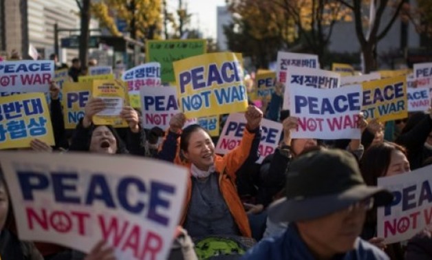 Demonstrators hold placards during a peace rally in Seoul - AFP