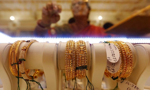 Gold bangles are on display as a woman makes choices at a jewellery showroom during Dhanteras, a Hindu festival associated with Lakshmi, the goddess of wealth, in Kolkata, India October 28, 2016. REUTERS/Rupak De Chowdhuri