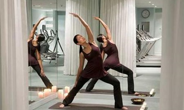 A woman practices yoga in the gym at Kimpton's Lorien Hotel and Spa in Washington, D.C. in this May 2009 handout. REUTERS/Fred Licht, Kimpton Hotels and ...