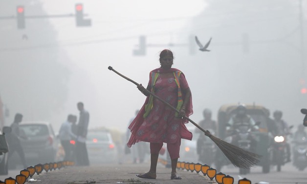A street cleaner works in heavy smog in Delhi, November 10, 2017. REUTERS/Cathal McNaughton