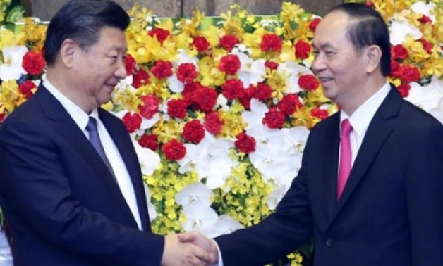 © POOL/AFP | Chinese President Xi Jinping (L) shakes hands with Vietnamese President Tran Dai Quang (R) at the presidential palace in Hanoi