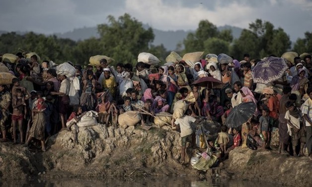 Rohingya refugees wait after crossing the Naf river from Myanmar into Bangladesh in Whaikhyang on October 9. Photo: AFP / FRED DUFOUR