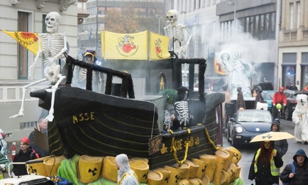 Demonstrators dressed as human skeletons stand on a ship-designed float swimming on symbolical nuclear waste during a protest of the action group 'No Climate Change', in Bonn, Germany, on November 11, 2017