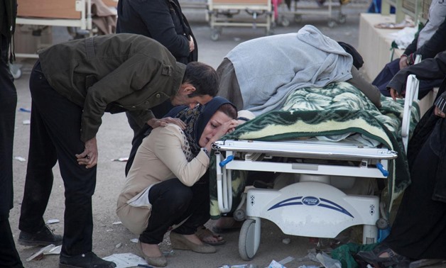 A woman reacts next to a dead body following an earthquake in Sarpol-e Zahab county in Kermanshah, Iran. REUTERS/Tasnim News Agency
