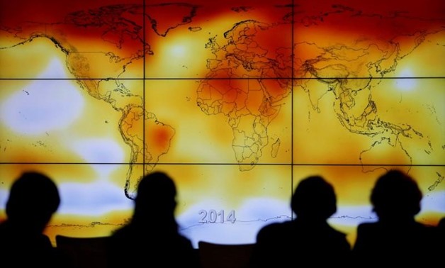 Participants are seen in silhouette as they look at a screen showing a world map with climate anomalies during the World Climate Change Conference 2015 (COP21) at Le Bourget, near Paris, France, December 8, 2015. REUTERS/Stephane Mahe/File Photo