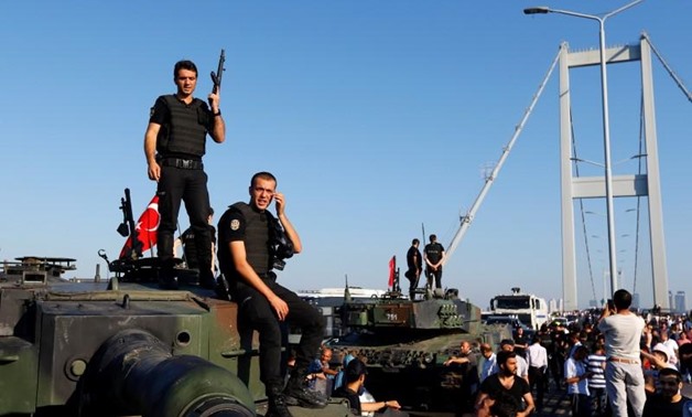 Policemen stand atop military armored vehicles after troops involved in the coup surrendered on the Bosphorus Bridge in Istanbul, Turkey July 16, 2016 - Reuters 