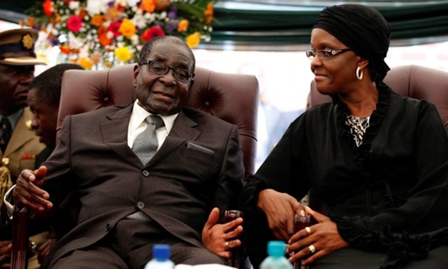 Zimbabwe President Robert Mugabe (L) speaks to his wife Grace during the funeral of his sister, Bridget in the village of Zvimba, Zimbabwe January 21 2014 -
 REUTERS/Philimon Bulawayo