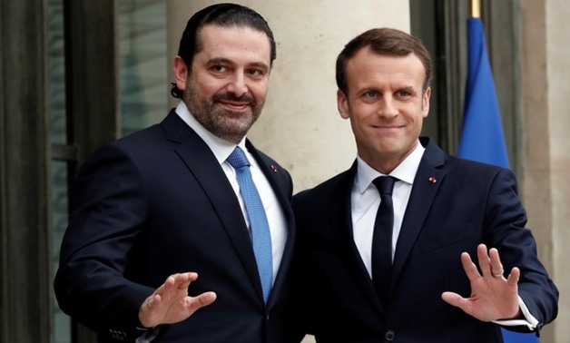 French President Emmanuel Macron and Saad al-Hariri, who announced his resignation as Lebanon's prime minister while on a visit to Saudi Arabia, react on the steps of the Elysee Palace in Paris, France, November 18, 2017. REUTERS/Benoit Tessier