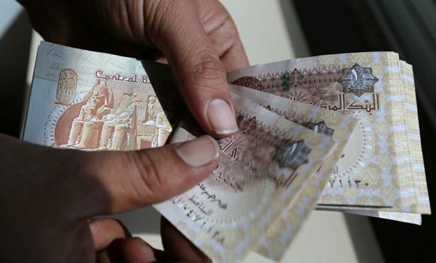 A man counts Egyptian notes outside bank in Cairo, Egypt October 24, 2016. REUTERS/Mohamed Abd El Ghany