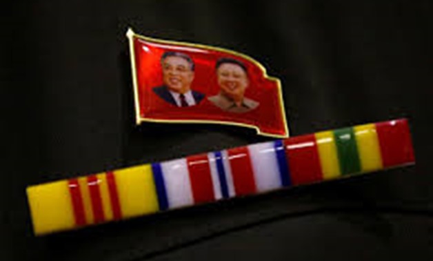 A North Korea fan wears a pin of North Korea founder Kim Il Sung and late leader Kim Jong Il. REUTERS/Toru Hanai