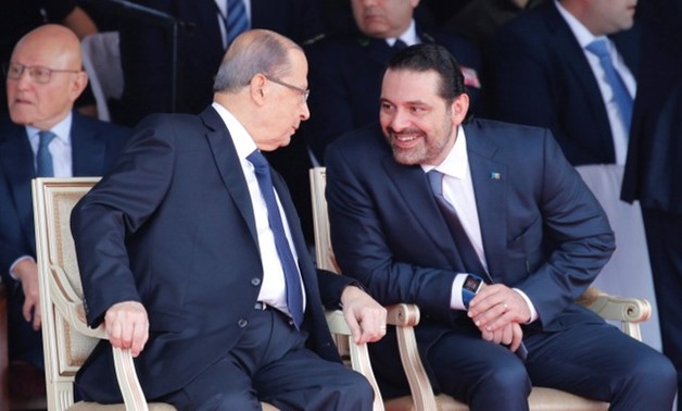 Saad al-Hariri, who announced his resignation as Lebanon's prime minister from Saudi Arabia reacts as he talks with Lebanese President Michel Aoun while attending a military parade to celebrate the 74th anniversary of Lebanon's independence in downtown Be