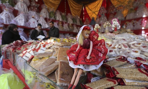 A man sells traditional doll toys and sweets for children to celebrate the birthday of prophet Muhammad, also known as “mawlid al nabi”, which will fall next week, in a makeshift tent in Cairo, December 30, 2014. (Photo by Mohamed Abd El Ghany/Reuters)