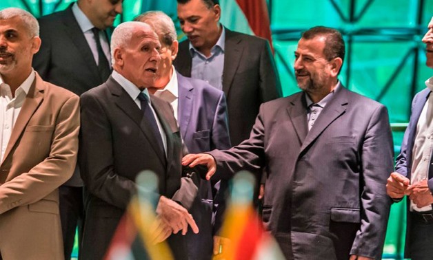 Heads of Fatah and Hamas delegations, Azzam al-Ahmad (L) and Saleh al-Aruri (R) after signing a reconciliation deal in Cairo, October 12, 2017. KHALED DESOUKI/AFP