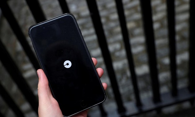 FILE PHOTO: The Uber logo is seen on mobile telephone in London, Britain, September 25, 2017. REUTERS/Hannah McKay