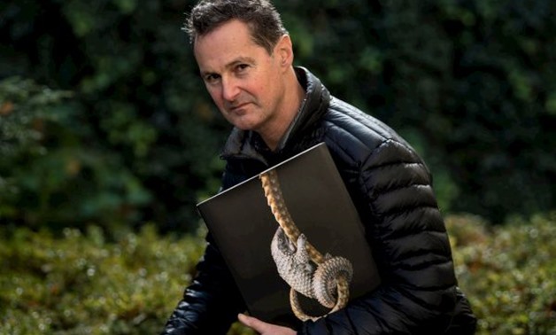 London-based photographer Tim Flach poses with his book "Endangered" November 13, 2017 in Washington, DC. As a child, Tim Flach would immerse himself in the outdoors, becoming so attuned to the natural world that he could feel a bee's energy as it streake