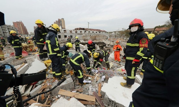 Rescue workers look for survivors after an explosion in Ningbo, China's eastern Zhejiang province which sent dozens to hospitals, destroyed vehicles, and triggered the collapse of nearby buildings - AFP