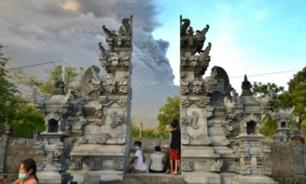 © AFP / by Sonny Tumbelaka | Balinese people look at Mount Agung during an eruption seen from Kubu sub-district in Karangasem Regency on Indonesia's resort island of Bali on November 26, 2017