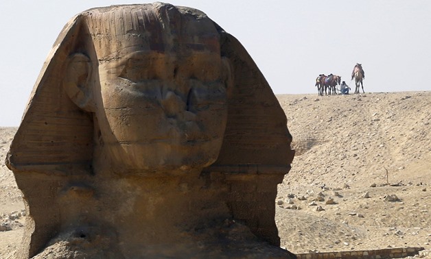 An employee waits with his camel for tourists near the Sphinx at the Giza Pyramids on the outskirts of Cairo, Egypt. Credit: Reuters/Amr Abdallah Dalsh