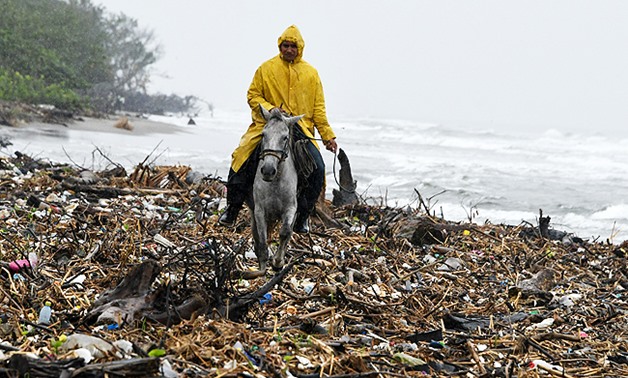 A man rides his horse amidst garbage at Omoa beach. Floating masses of garbage offshore from some of the Caribbean’s pristine beaches are testimony to a vast and growing problem of plastic pollution heedlessly dumped in our oceans, locals, activists and e