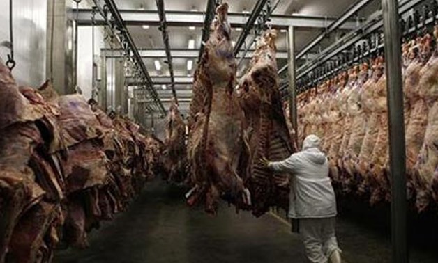 A worker arranges slaughtered cattle in the freezing room in a slaughter house in Brazil - Reuters
