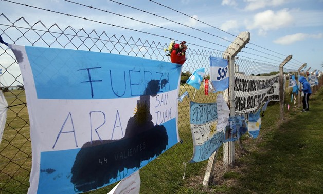 A bouquet of flowers is seen placed next to banners in support of the 44 crew members of the missing at sea ARA San Juan submarine, on a fence outside an Argentine naval base in Mar del Plata, Argentina November 24, 2017. REUTERS/Marcos Brindicci

