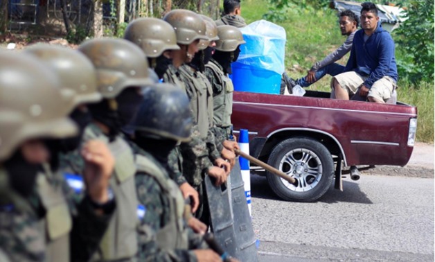 Soldiers stand at a check point as they guard the city after the Honduras government enforced a curfew on Saturday while still mired in chaos