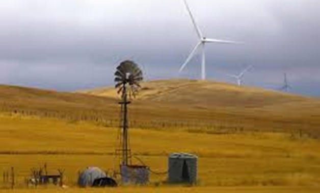An old windmill stands in front of wind turbines in a paddock near the Hornsdale Power Reserve, featuring the world's largest lithium ion battery made by Tesla, located on the outskirts of the South Australian town of Jamestown, in Australia, December 1, 