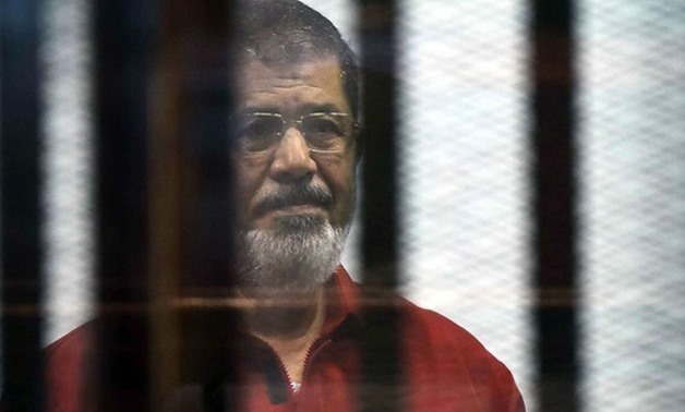 FILE – Former President Mohammed Morsi behind bars