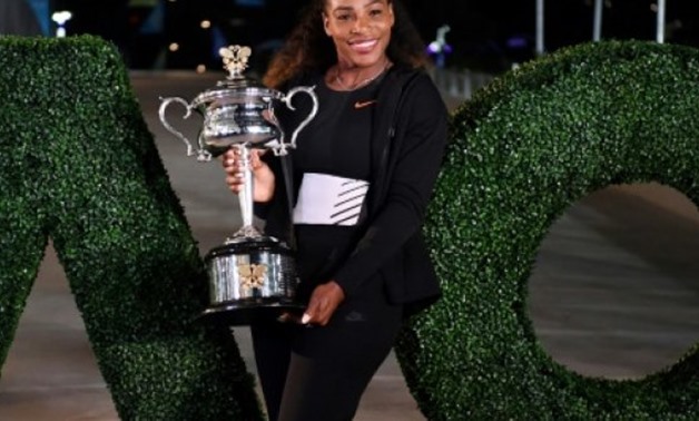 © AFP/File | Serena Williams poses with the 2017 Australian Open championship trophy after her victory against Venus Williams in Melbourne in January