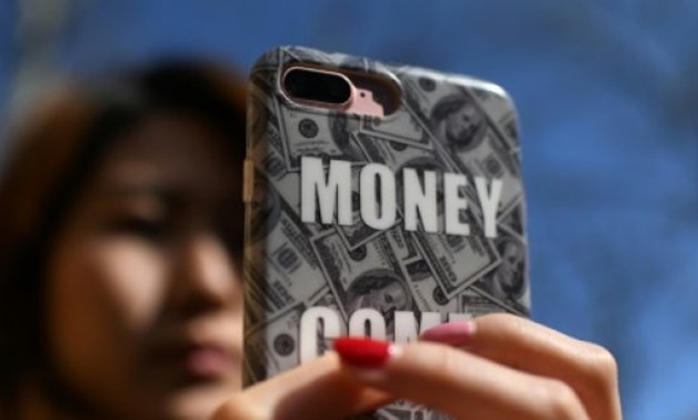 © AFP / by Ryan MCMORROW | Smartphones have made it even easier for consumers to borrow cash in China and a number of online platforms have listed publicly in the US this year