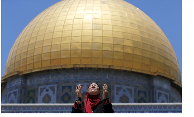 A Palestinian woman prays in front of the Dome of the Rock on the first Friday of the holy month of Ramadan at the compound known to Muslims as the Noble Sanctuary and to Jews as Temple Mount, in Jerusalem's Old City June 19, 2015. REUTERS/Ammar Awad/File