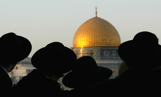 Ultra-Orthodox Jews look at the Dome of the Rock in the Old City during a demonstration of some 200 right-wing Israelis in Jerusalem on August 8, 2002. REUTERS/Oleg Popov/File Photo