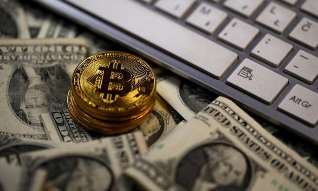 A bitcoin (virtual currency) coin placed on Dollar banknotes, next to computer keyboard, is seen in this illustration picture, November 6, 2017. REUTERS/Dado Ruvic/Illustration
