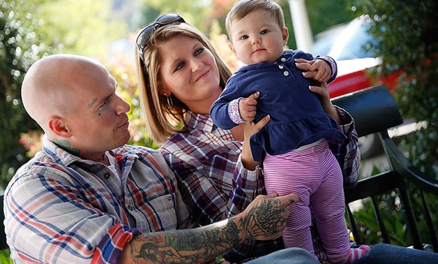 DOING WELL: Father Donnie Gooding and mother Katy Yeager play with their daughter, Kennedy. Almost a year has passed since Kennedy was born in drug withdrawal. Yeager, at risk of losing the baby, took a gamble on a new program for mothers battling addicti