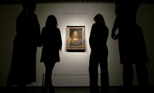 FILE PHOTO: Members of Christie's staff pose for pictures next to Leonardo da Vinci's "Salvator Mundi" painting in London, October 24, 2017. REUTERS/Peter Nicholls/File Photo