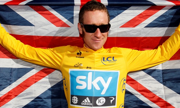 Sky Procycling rider and leader's yellow jersey Bradley Wiggins of Britain celebrates with a British national flag on the Champs Elysees after winning the 99th Tour de France cycling race in Paris, France, July 22, 2012 - REUTERS/Stephane Mahe/F