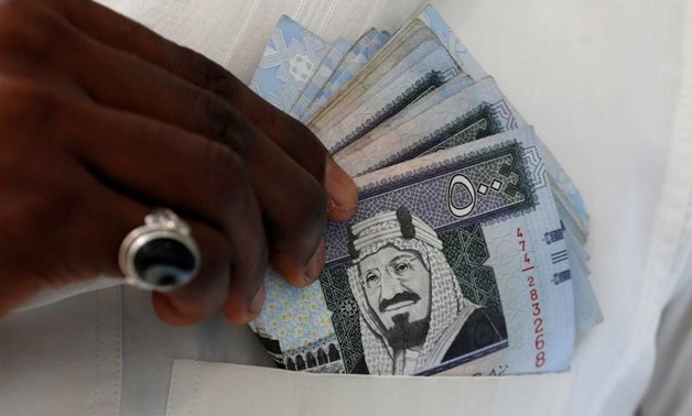  A Saudi man shows Saudi riyal banknotes at a money exchange shop, in Riyadh, Saudi Arabia January 20, 2016. REUTERS/Faisal Al Nasser