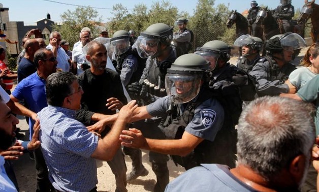 Israeli policemen scuffle with Arab Israelis during a demonstration held by Israeli right-wing protesters (not pictured) near the family home of Nashat Melhem, an Arab Israeli who killed three people in a Jan. 1 shooting attack, in the northern Arab Israe