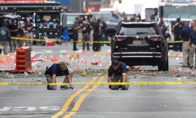 Federal Bureau of Investigation (FBI) officials mark the ground near the site of an explosion in the Chelsea neighborhood of Manhattan, New York, U.S. September 18, 2016. REUTERS/Rashid Umar Abbasi