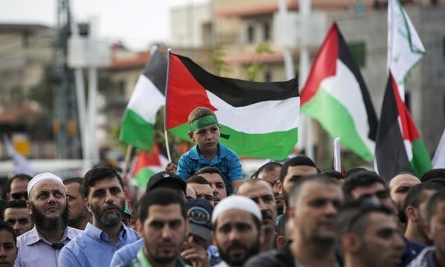 Israeli-Arabs hold Palestinian flags during a demonstration in the northern Israeli town of Sakhnin October 13, 2015. REUTERS/Baz Ratner