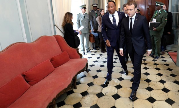 French President Emmanuel Macron (R) and Niger's President Mahamadou Issoufou arrive for a meeting ahead of a summit with leaders of the G5 Sahel countries to discuss how to speed up the implementation of the G5 West African counter-terrorism force at La 