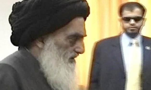 Video image shows Ayatollah Ali al-Sistani, Iraq's powerful religious leader (L) upon his arrival in the southern city of Basra, as security watches, August 25, 2004. REUTERS/Reuters TV