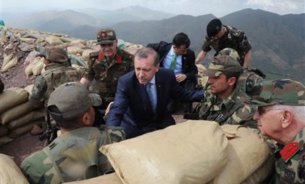 Turkish Prime Minister Tayyip Erdogan (C) speaks with Turkish soldiers in a trench during his visit to the Turkish city of Hakkari at the border with Iraq June 20, 2010. REUTERS/Kayhan Ozer/Anatolian