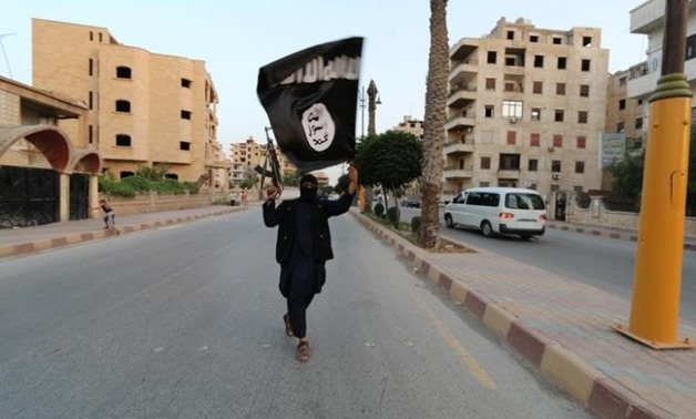 A member loyal to the Islamic State in Iraq and the Levant (ISIL) waves an ISIL flag in Raqqa June 29, 2014. REUTERS/Stringer